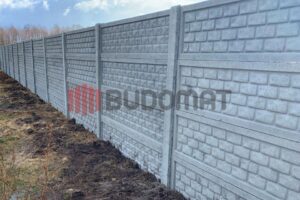 Montaż ogrodzenia betonowego ze wzorem cegły z wykorzystaniem słupów oraz pełnych płyt.