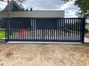 Wjazd na posesję z bramą przesuwną z napędem i automatyką